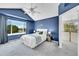 A primary bedroom with blue walls, a large window, and a ceiling fan, offering comfort and style at 3406 Purcell St, Brighton, CO 80601