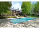 Resort-style backyard with pool, lush landscaping, and a spacious patio area for relaxation at 5 Churchill Dr, Cherry Hills Village, CO 80113
