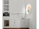 Wet bar area featuring white cabinets, marble countertops, built-in appliances and a round window at 5 Churchill Dr, Cherry Hills Village, CO 80113