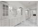 Spacious bathroom featuring marble floors and countertops, custom cabinetry, and a walk-through design at 5 Churchill Dr, Cherry Hills Village, CO 80113