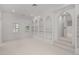 Bright bonus room with built-in arched bookshelves, neutral carpet, and abundant natural light at 5 Churchill Dr, Cherry Hills Village, CO 80113