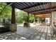 Relaxing covered patio with overhead trellis, stone accents, and views of the lush backyard and pool at 5 Churchill Dr, Cherry Hills Village, CO 80113