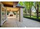 Outdoor living space with a stone fireplace and lush backyard views from this covered patio at 5 Churchill Dr, Cherry Hills Village, CO 80113