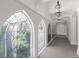 Light-filled hallway with large arched windows overlooking lush greenery, accented by elegant pendant lighting at 5 Churchill Dr, Cherry Hills Village, CO 80113
