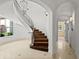 A sweeping staircase features wrought iron railings, sconces, and access to arched hallways at 5 Churchill Dr, Cherry Hills Village, CO 80113
