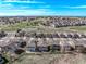 An aerial view of a neighborhood of modern homes close to a golf course and rolling hills under a blue sky at 23757 Eagle Bend Ln, Parker, CO 80138