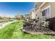 A well-maintained backyard featuring a stone patio with outdoor furniture, a manicured lawn, and a wooden fence at 23757 Eagle Bend Ln, Parker, CO 80138
