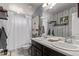 Bathroom with double vanity, patterned accent wall, and stylish coastal decor at 23757 Eagle Bend Ln, Parker, CO 80138