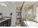 Well lit bathroom boasts double sinks, shower, garden tub, dark cabinets, and tile flooring at 23757 Eagle Bend Ln, Parker, CO 80138