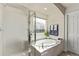 Bright bathroom featuring tiled shower, soaking tub, and natural light from the window at 23757 Eagle Bend Ln, Parker, CO 80138