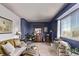 Charming bedroom with blue accent wall, large window, comfortable couch, plants, and neutral carpet at 23757 Eagle Bend Ln, Parker, CO 80138