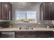 Kitchen with a stainless steel sink beneath a window bringing in natural light, and dark cabinets for ample storage at 23757 Eagle Bend Ln, Parker, CO 80138