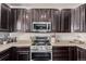 A kitchen showcasing stainless steel appliances and dark wood cabinets with plenty of counter space for meal preparation at 23757 Eagle Bend Ln, Parker, CO 80138