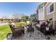 Back patio with stone pavers, seating area, grill, grass, and backyard view at 23757 Eagle Bend Ln, Parker, CO 80138