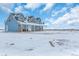 Blue two-story house with a large yard in a snowy landscape at 14199 County Road 26, Fort Lupton, CO 80621