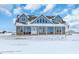 Two-story home with a wrap-around porch, stone accents and a snow-covered yard at 14199 County Road 26, Fort Lupton, CO 80621