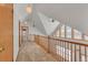 Upper hallway with wood railing, pendant lights, and carpeted flooring at 14199 County Road 26, Fort Lupton, CO 80621