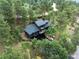 Aerial view of a modern home surrounded by lush greenery with a serene setting and exterior decks at 28833 Western Dr, Evergreen, CO 80439