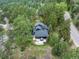 Aerial view of home with a large deck nestled in a wooded area with mature trees at 28833 Western Dr, Evergreen, CO 80439