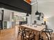Open-concept dining room with modern lighting, a large wooden table, and a view into the stylish kitchen at 28833 Western Dr, Evergreen, CO 80439