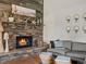 Living room showcasing a stone fireplace, rustic decor, and a comfortable seating area at 28833 Western Dr, Evergreen, CO 80439