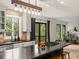 Spacious kitchen featuring a large island with a cooktop and bar seating, with sliding glass doors and lush greenery at 28833 Western Dr, Evergreen, CO 80439