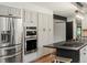 Kitchen with stainless steel refrigerator and double oven, paired with gray cabinets and black countertop island at 28833 Western Dr, Evergreen, CO 80439