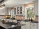 Bright kitchen featuring gray cabinets, stainless steel appliances, black countertops, and a unique tile backsplash at 28833 Western Dr, Evergreen, CO 80439