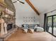 Inviting living room with a stone fireplace, vaulted ceilings, and large windows offering scenic views at 28833 Western Dr, Evergreen, CO 80439