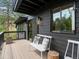 Inviting porch with a bench, stylish pillows, and views of the lush surrounding landscape at 28833 Western Dr, Evergreen, CO 80439