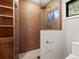 Modern walk-in shower with stylish wood-look tile, a rain showerhead, and a glass enclosure at 28833 Western Dr, Evergreen, CO 80439