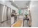 Galley kitchen with white cabinets, stainless steel appliances, and natural light at 3002 Quitman St, Denver, CO 80212