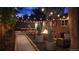 Backyard with cozy firepit, stylish seating, trees, and string lights for nighttime ambiance at 1830 S Fillmore St, Denver, CO 80210