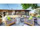 Stylish backyard patio featuring a central stone fire pit, comfortable seating, string lights, and lush plantings at 1830 S Fillmore St, Denver, CO 80210