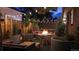 Inviting backyard patio at night, featuring a fire pit, comfortable seating, string lights, and a privacy fence at 1830 S Fillmore St, Denver, CO 80210
