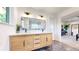 Modern bathroom boasts double sink vanity, black hardware, quartz countertop, large mirror, and leads to bedroom at 1830 S Fillmore St, Denver, CO 80210