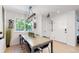Bright dining area with a long wooden table, unique light fixtures, and backyard view at 1830 S Fillmore St, Denver, CO 80210