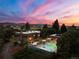 Stunning twilight aerial view of home with a pool and mountain views in the background at 3675 S Perry Park Rd, Sedalia, CO 80135