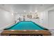 Billiards table with overhead lighting. Cue rack, wall decor, and kitchenette in background at 6052 Taft St, Arvada, CO 80004