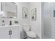 Bathroom features white fixtures, tiled shower, large mirror and modern vanity at 6052 Taft St, Arvada, CO 80004