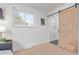 Bedroom featuring natural light from windows, a barn door, hardwood floors, and neutral paint at 6052 Taft St, Arvada, CO 80004