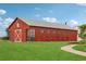 Large red barn featuring a white 'R' on the side, and a long row of windows, set on a lush green lawn at 16595 E 110Th Ave, Commerce City, CO 80022