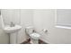 Clean and modern powder room featuring a pedestal sink, toilet, and crisp white walls at 16595 E 110Th Ave, Commerce City, CO 80022
