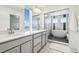 Bright bathroom featuring double sinks, quartz countertops, and a soaking tub at 16595 E 110Th Ave, Commerce City, CO 80022