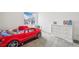 Fun bedroom with a car-shaped bed and white dresser at 16595 E 110Th Ave, Commerce City, CO 80022