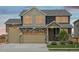 Charming two-story home featuring a three-car garage, stone accents, and a covered front porch at 16595 E 110Th Ave, Commerce City, CO 80022