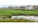 Golf course homes surround a pond with lush green grass and landscaping, a picturesque golf community at 16595 E 110Th Ave, Commerce City, CO 80022
