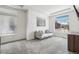 Sunlit living room with a comfortable couch and scenic neighborhood views through large windows at 16595 E 110Th Ave, Commerce City, CO 80022