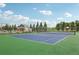 Outdoor tennis court with trees and a covered pavilion in the background at 16595 E 110Th Ave, Commerce City, CO 80022