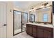 Modern bathroom with a glass-enclosed shower, double sink vanity, and wood-trimmed mirror at 17859 E 108Th Pl, Commerce City, CO 80022